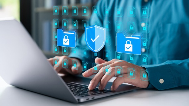 Cybersecurity concept with businessman using a laptop to protect data folders and digital files. Represents data privacy, secure information, and advanced cyber protection.
