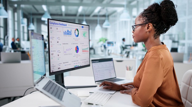 African American Woman Inspects Regulatory Dashboard On Corporate Officer's Laptop.