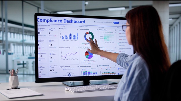Woman In Business Suit Using Touchscreen Computer To Monitor Regulations.